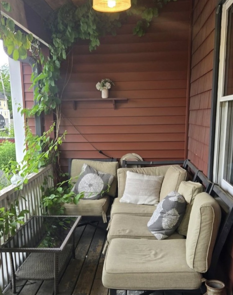 comfortable couch on outdoor deck with decorate vines